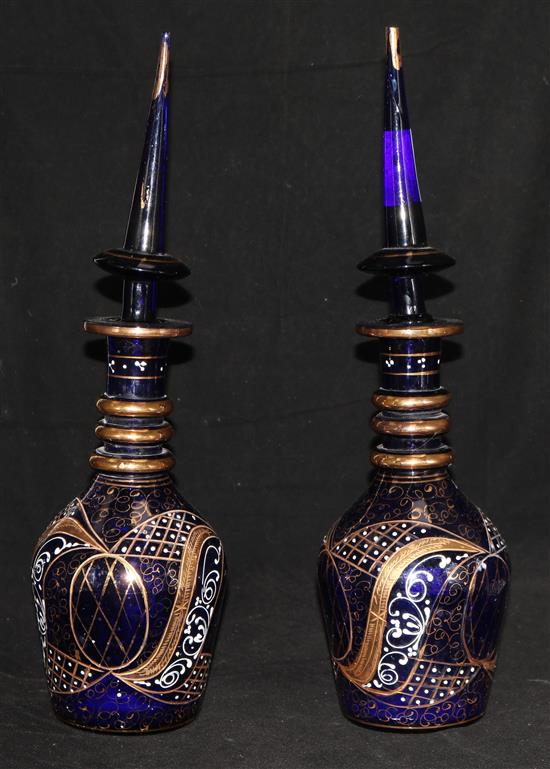 A pair of gilded and enamelled blue glass decanters and stoppers